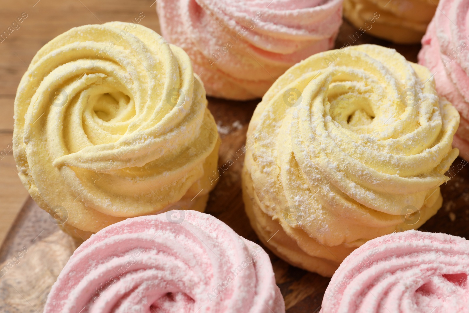 Photo of Delicious pink and yellow marshmallows on wooden table, closeup