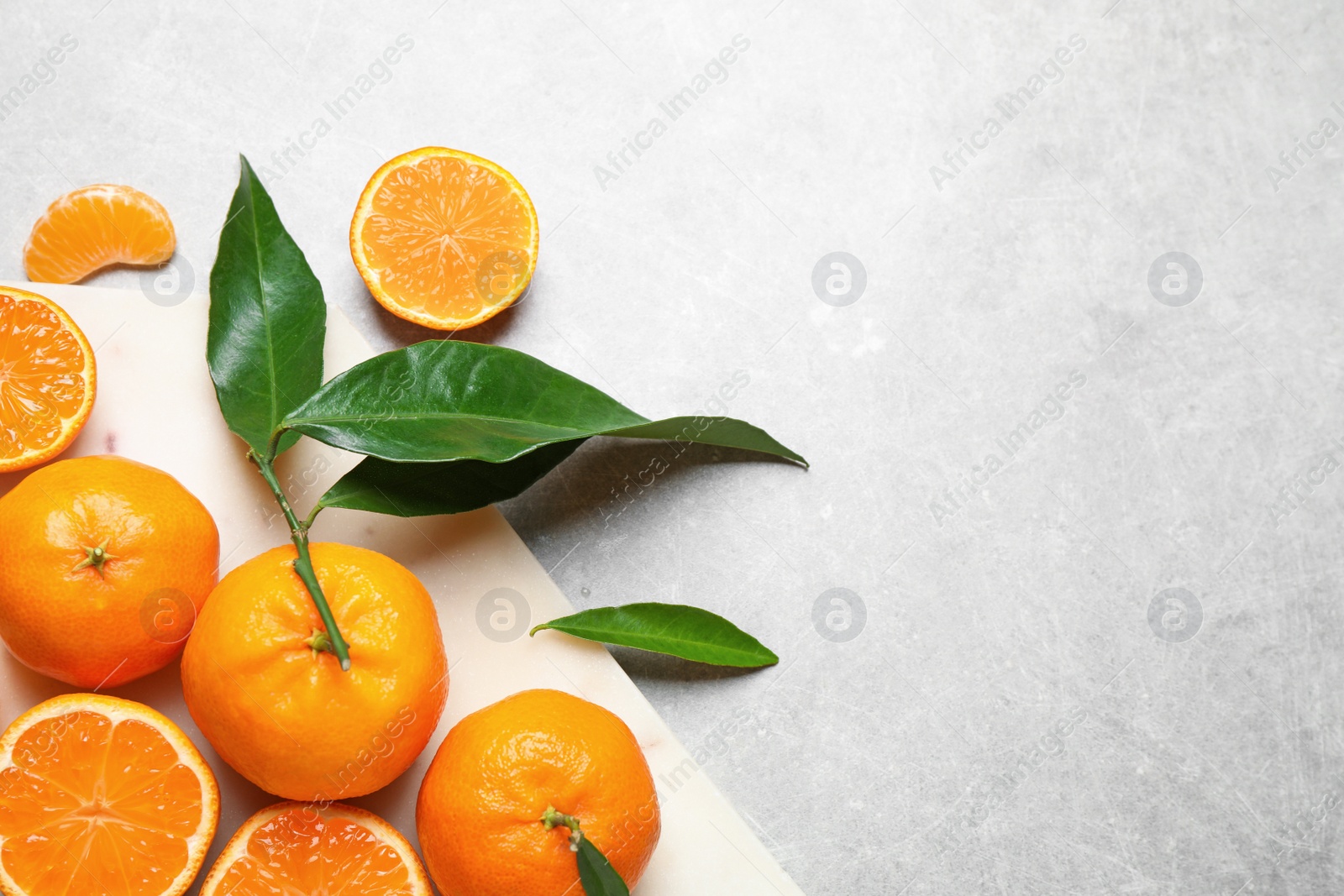 Photo of Fresh ripe tangerines and space for text on grey table, flat lay. Citrus fruit