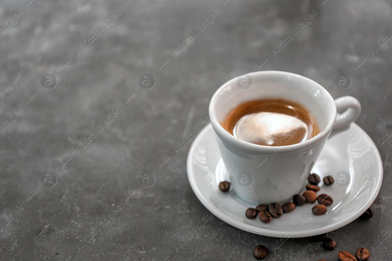 Photo of Cup of fresh aromatic coffee on grey background