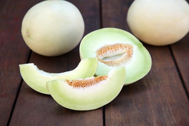 Tasty whole and cut ripe melons on wooden table