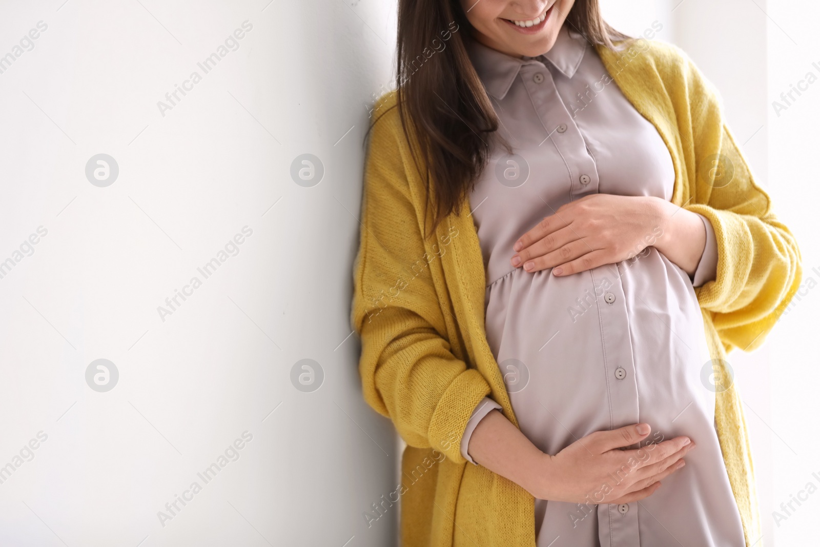 Photo of Young pregnant woman in casual clothes on light background