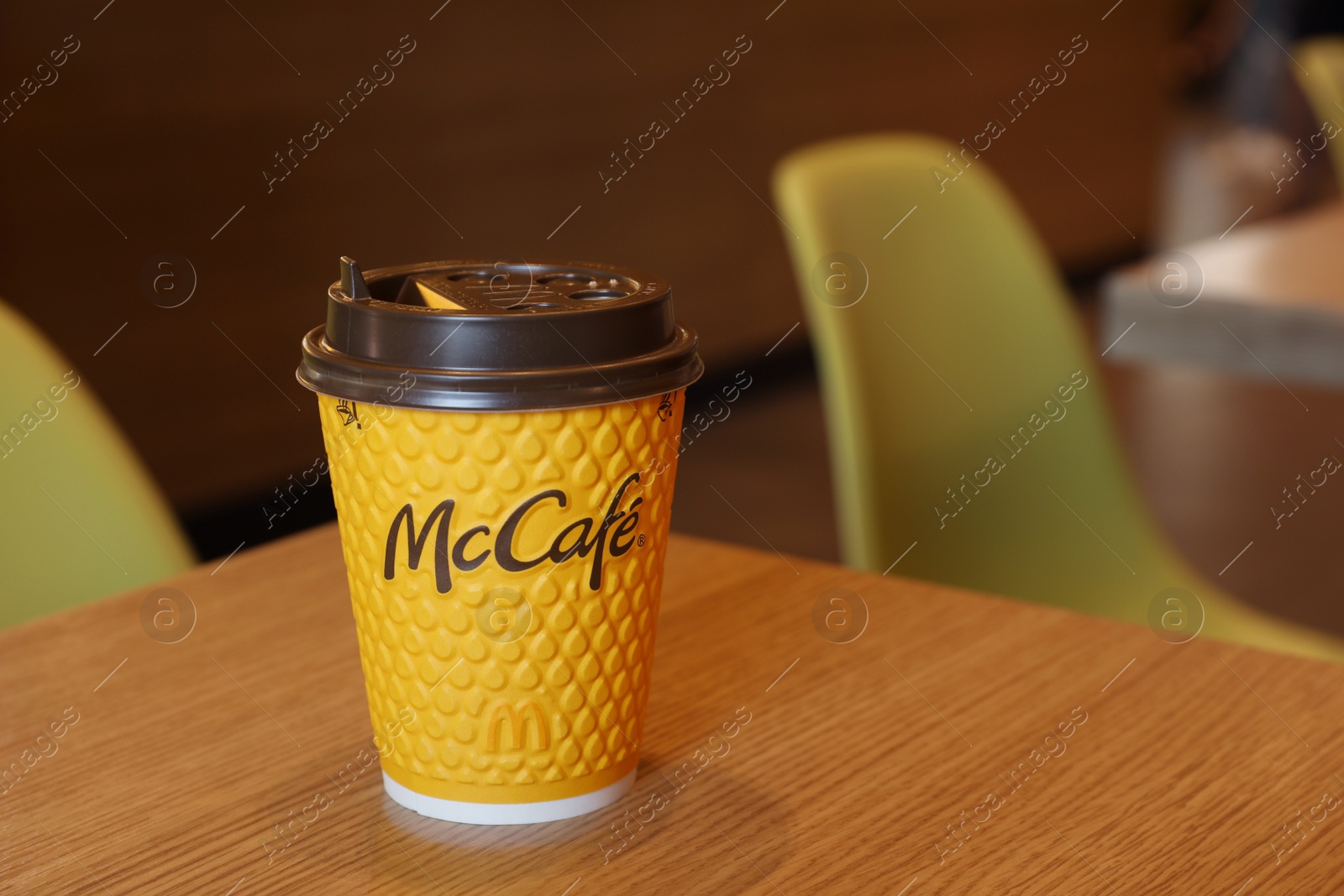 Photo of MYKOLAIV, UKRAINE - AUGUST 11, 2021: Hot McDonald's drink on table in cafe. Space for text