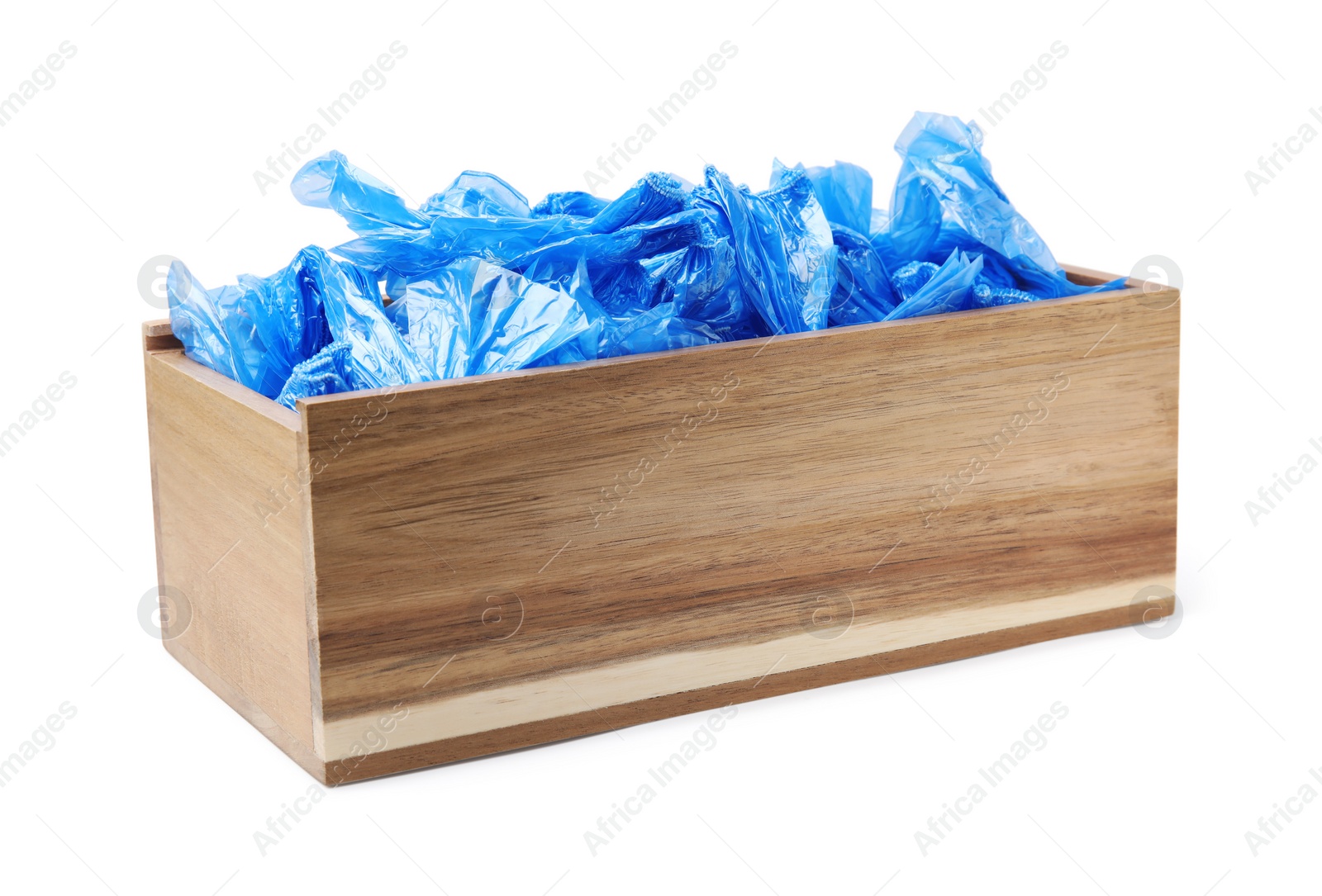 Photo of Blue medical shoe covers in wooden crate isolated on white