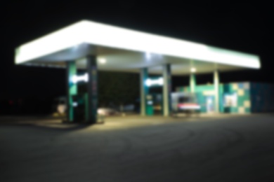 Photo of Blurred view of modern gas station with convenience store beside the road at night