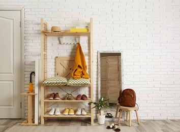 Cozy hallway interior with wooden shelving unit. Stylish design idea