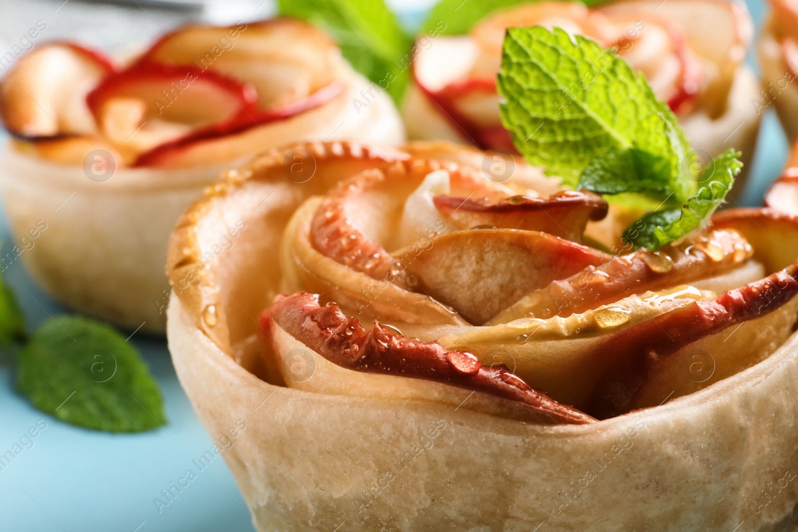 Photo of Freshly baked apple roses on plate, closeup. Beautiful dessert