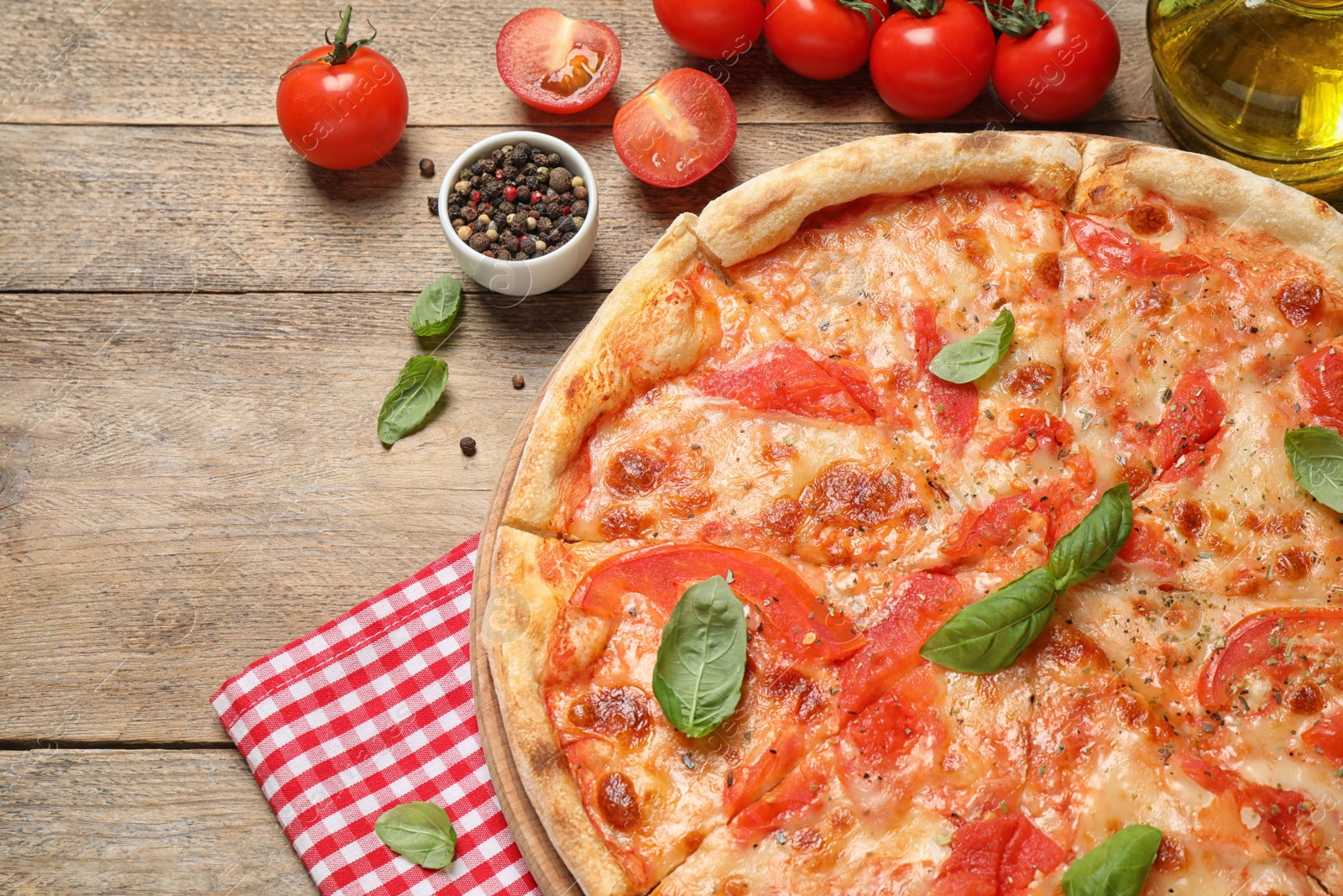 Photo of Delicious pizza Margherita and ingredients on wooden table, flat lay