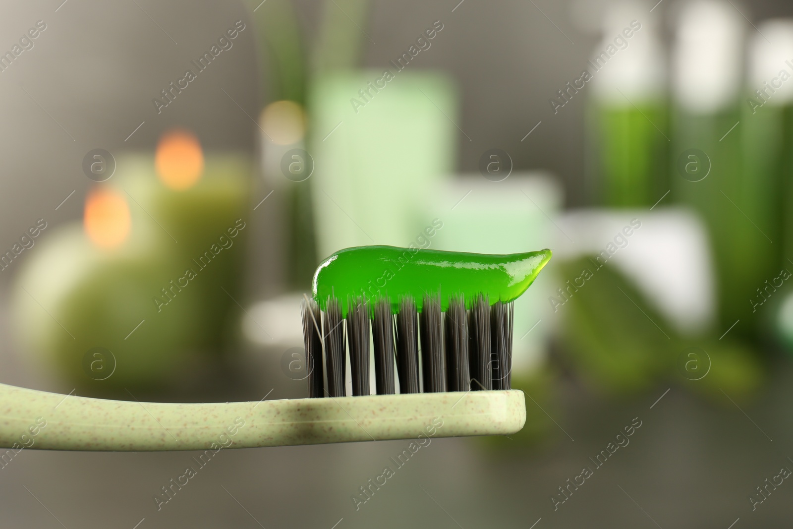 Photo of Aloe vera toothpaste on brush against blurred background, closeup