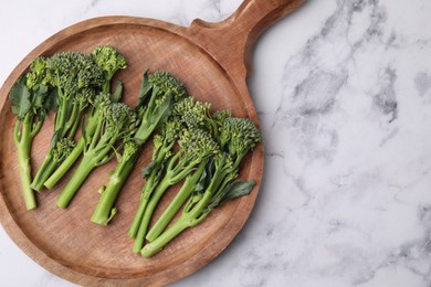 Fresh raw broccolini on white marble table, top view and space for text. Healthy food