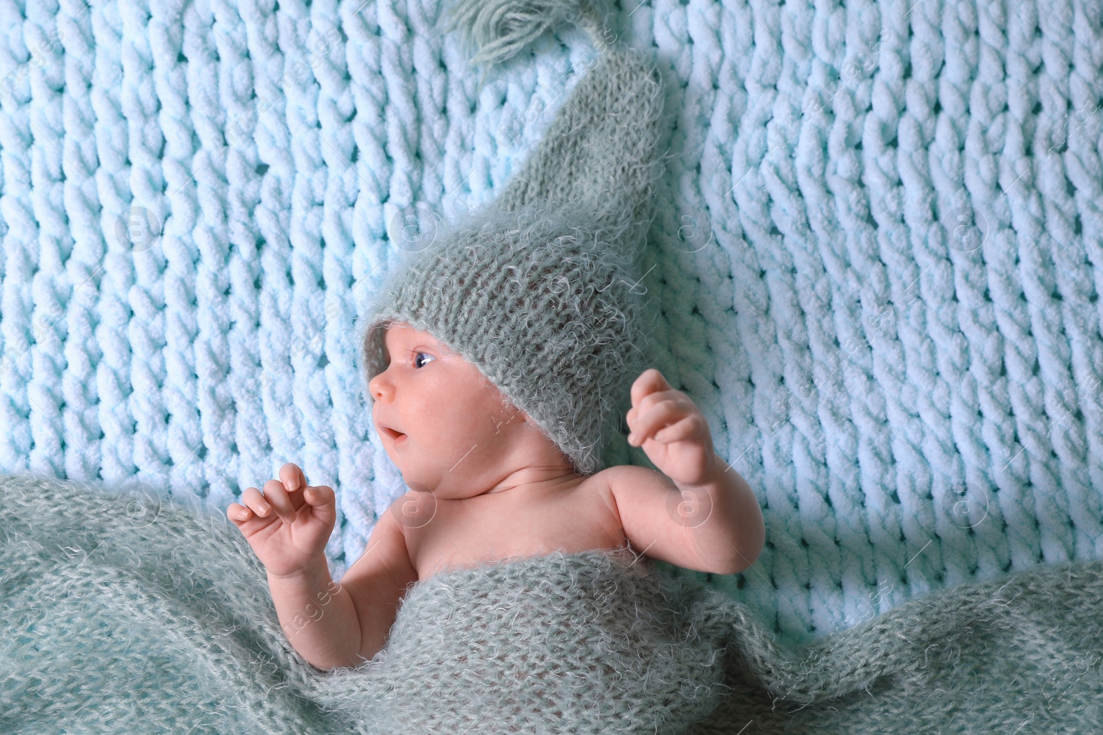 Photo of Cute newborn baby on light blue blanket, top view