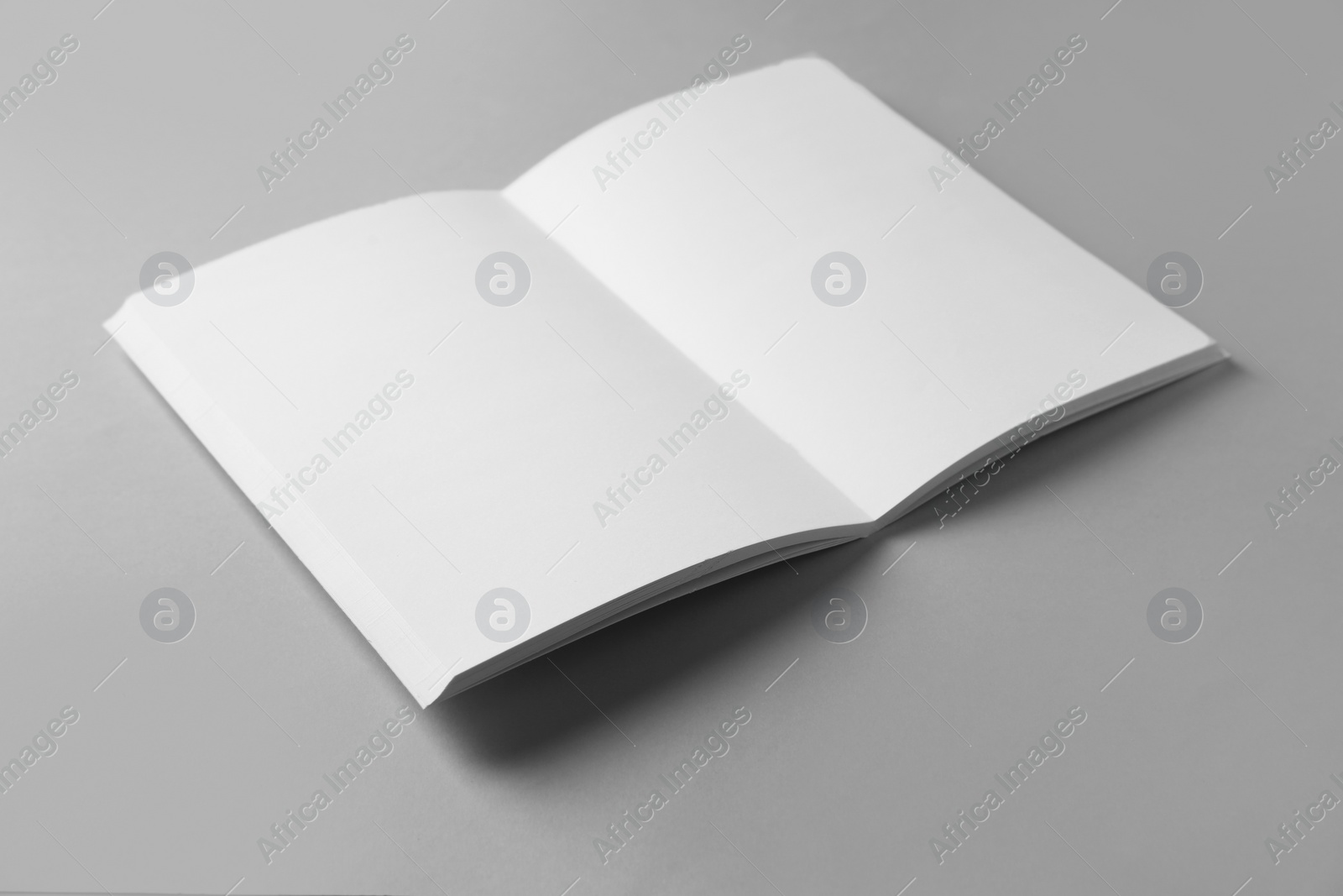 Photo of Open blank brochure on grey background. Mockup for design