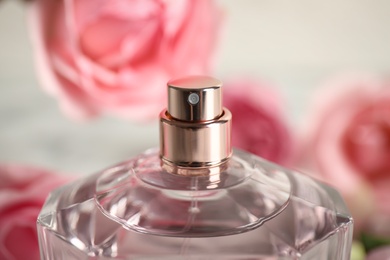 Photo of Bottle of perfume on blurred background, closeup