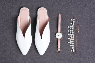 Pair of female shoes and accessories on gray background, top view