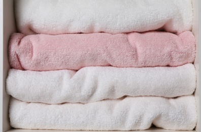 Photo of Colorful towels on shelf, closeup. Bathroom supplies