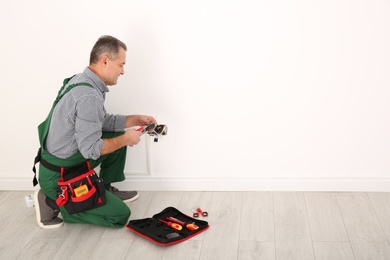 Professional electrician stripping wire ends indoors, space for text