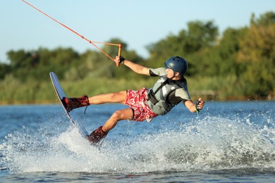 Teenage boy wakeboarding on river. Extreme water sport