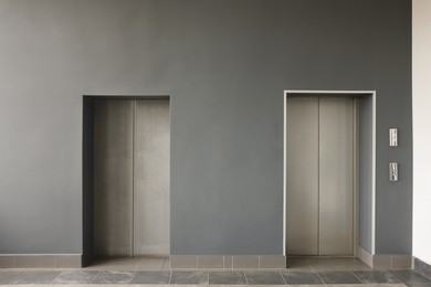 Closed stylish elevator doors in clean hall