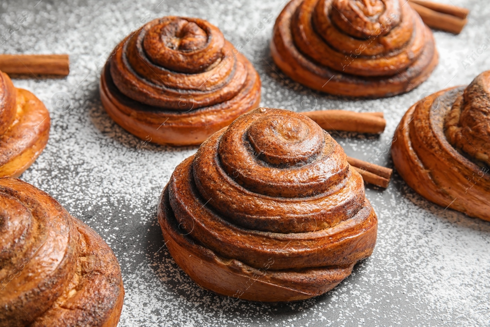 Photo of Cinnamon rolls and sugar powder on table