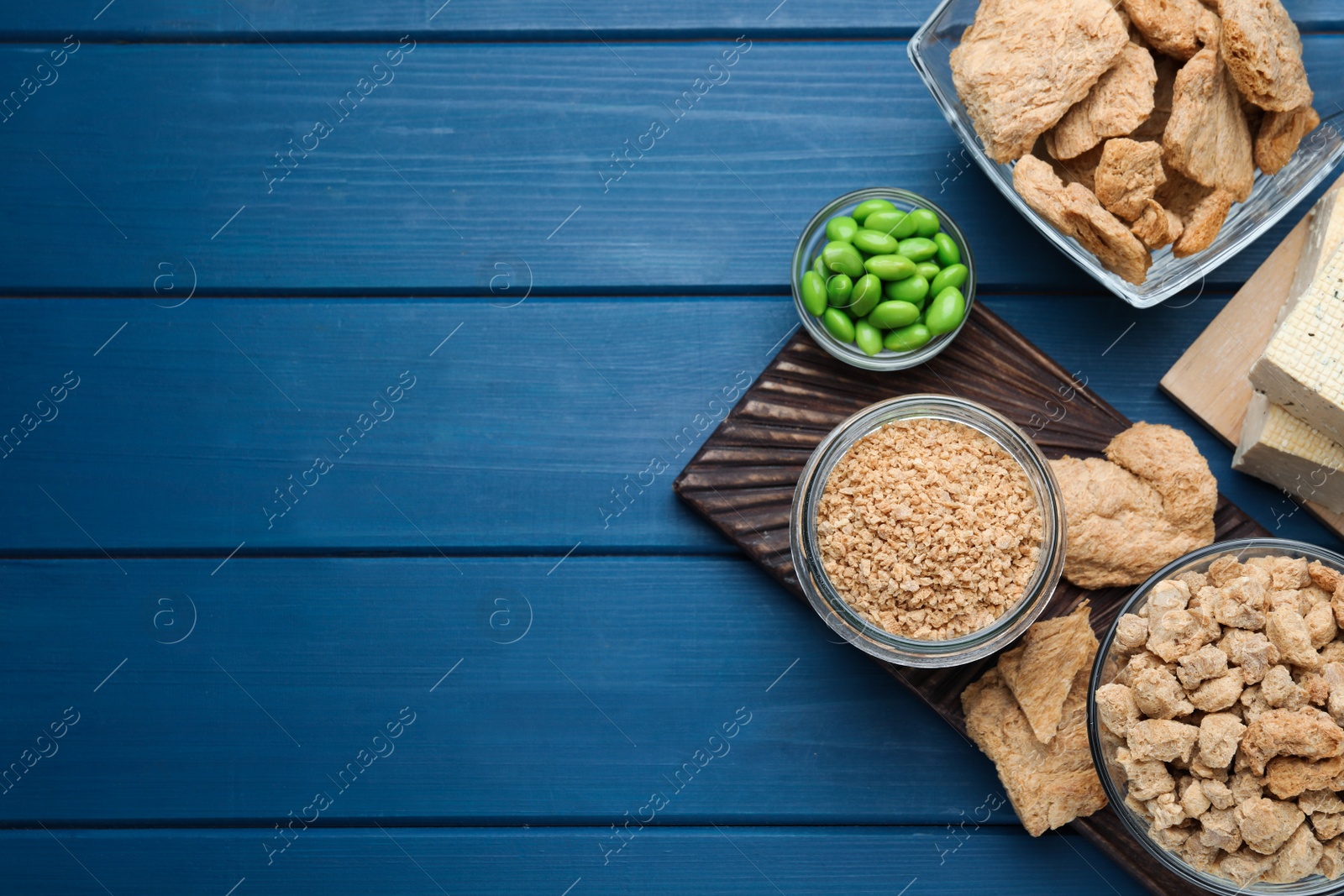 Photo of Different organic soy products on blue wooden table, flat lay. Space for text