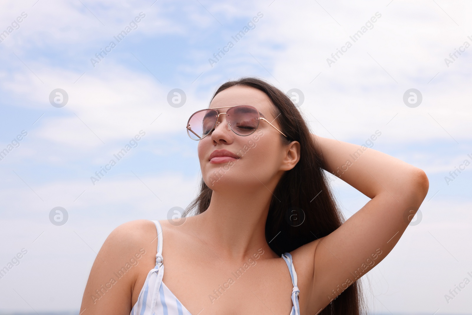 Photo of Beautiful young woman wearing stylish sunglasses outdoors