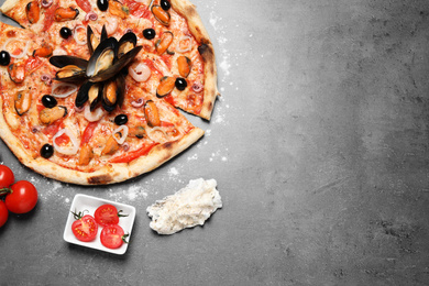 Tasty pizza with seafood and tomatoes on grey table, flat lay. Space for text