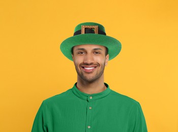 St. Patrick's day party. Man in green leprechaun hat on golden background