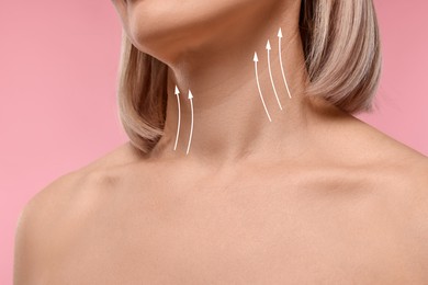 Image of Woman with perfect skin after cosmetic treatment on pink background, closeup. Lifting arrows on her neck