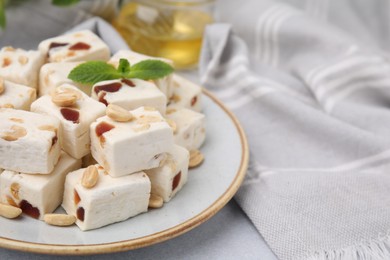 Photo of Pieces of delicious nutty nougat on light table, closeup