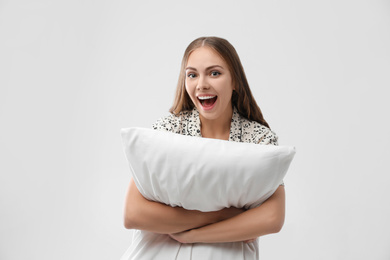 Photo of Beautiful woman with pillow on light grey background. Bedtime