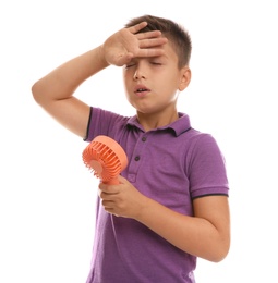 Little boy with portable fan suffering from heat on white background. Summer season