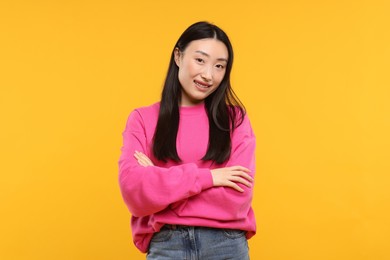 Photo of Portrait of smiling woman on orange background