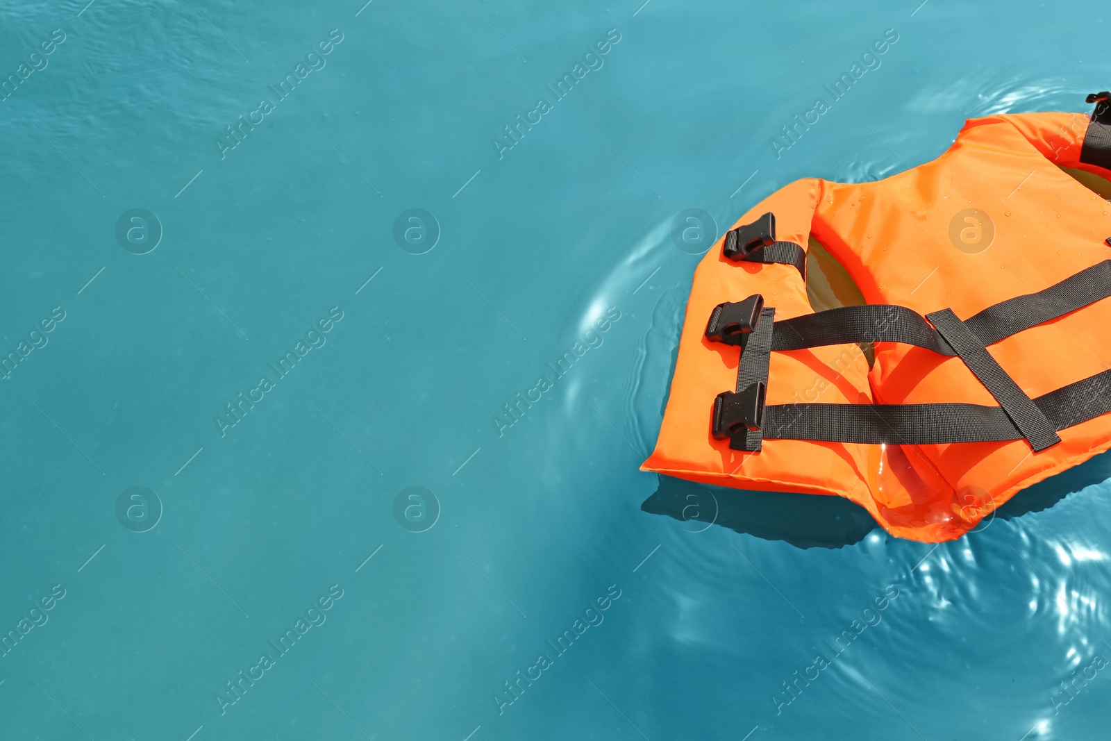 Photo of Orange life jacket floating in sea. Emergency rescue equipment