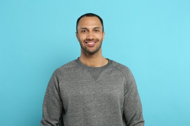 Photo of Portrait of handsome young man on light blue background