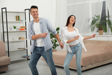 Photo of Happy young couple dancing together at home