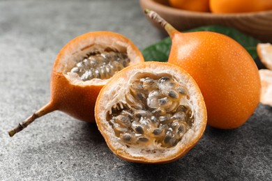 Photo of Delicious ripe granadillas on grey table, closeup