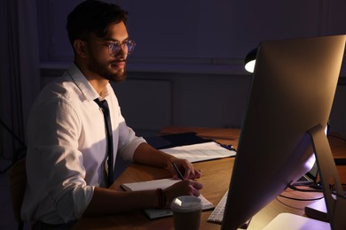 Tired young man working late in office