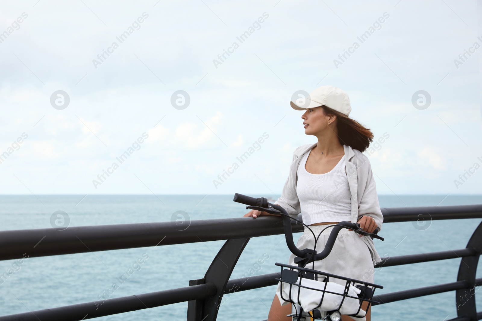 Photo of Beautiful young woman with bicycle near sea. Space for text