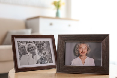 Photo of Portraits in stylish frames on table indoors