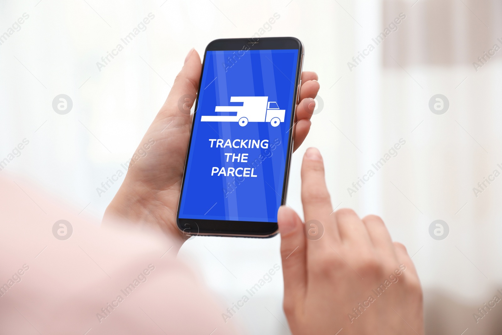 Image of Woman tracking parcel via smartphone indoors, closeup