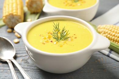 Photo of Delicious creamy corn soup served on grey wooden table