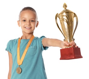 Photo of Happy girl with golden winning cup and medal on white background