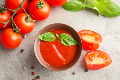 Photo of Flat lay composition with bowl of sauce and tomatoes on grey table