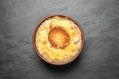 Tasty homemade french onion soup on black table, top view