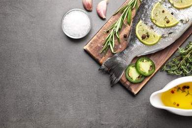 Fresh dorado fish and ingredients on grey table, flat lay. Space for text