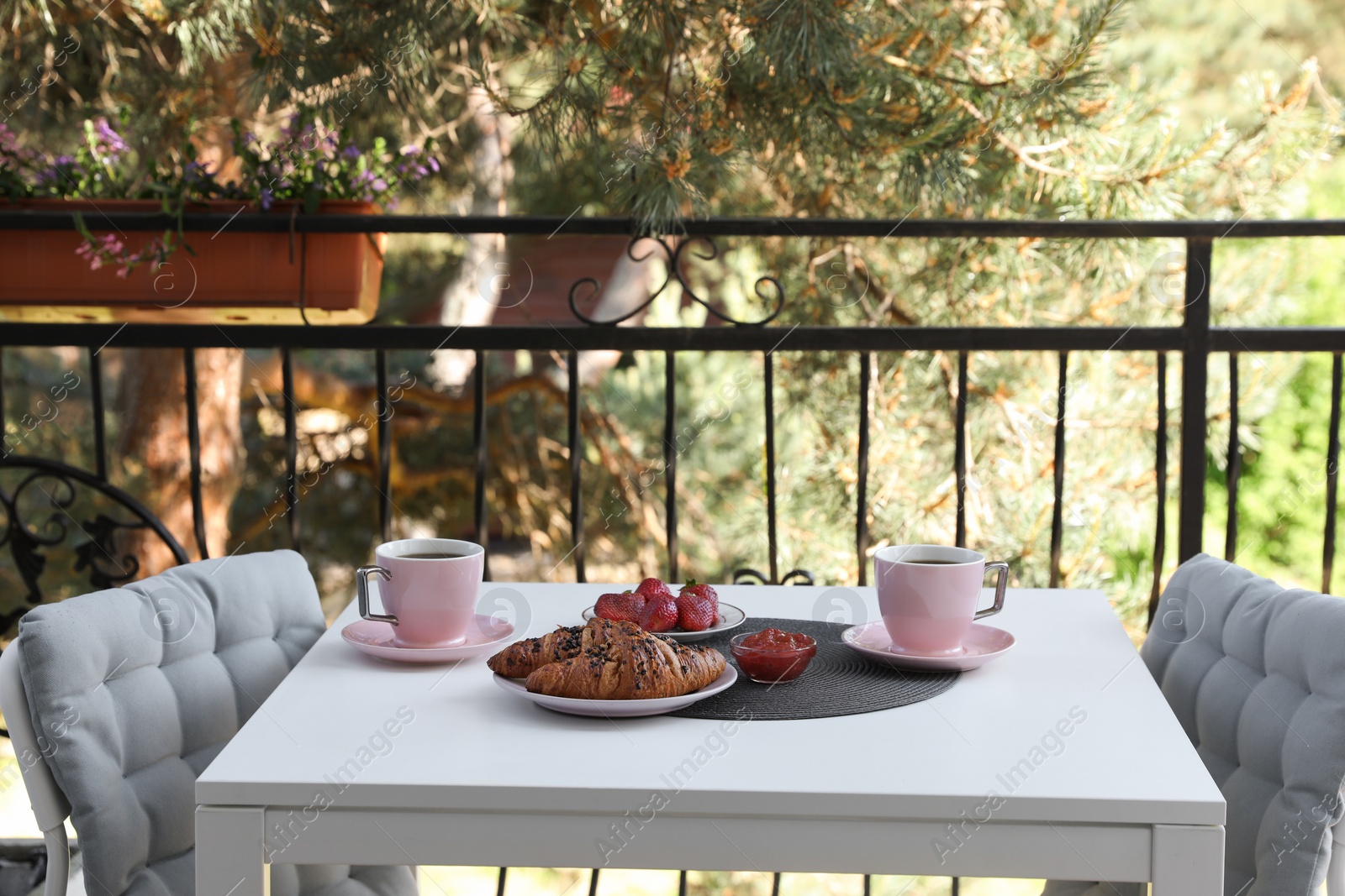Outdoor breakfast with tea and croissants on white table on terrace Photo of Outdoor breakfast with tea and croissants on white table on terrace