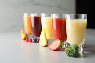 Photo of Delicious juices and fresh ingredients on grey table