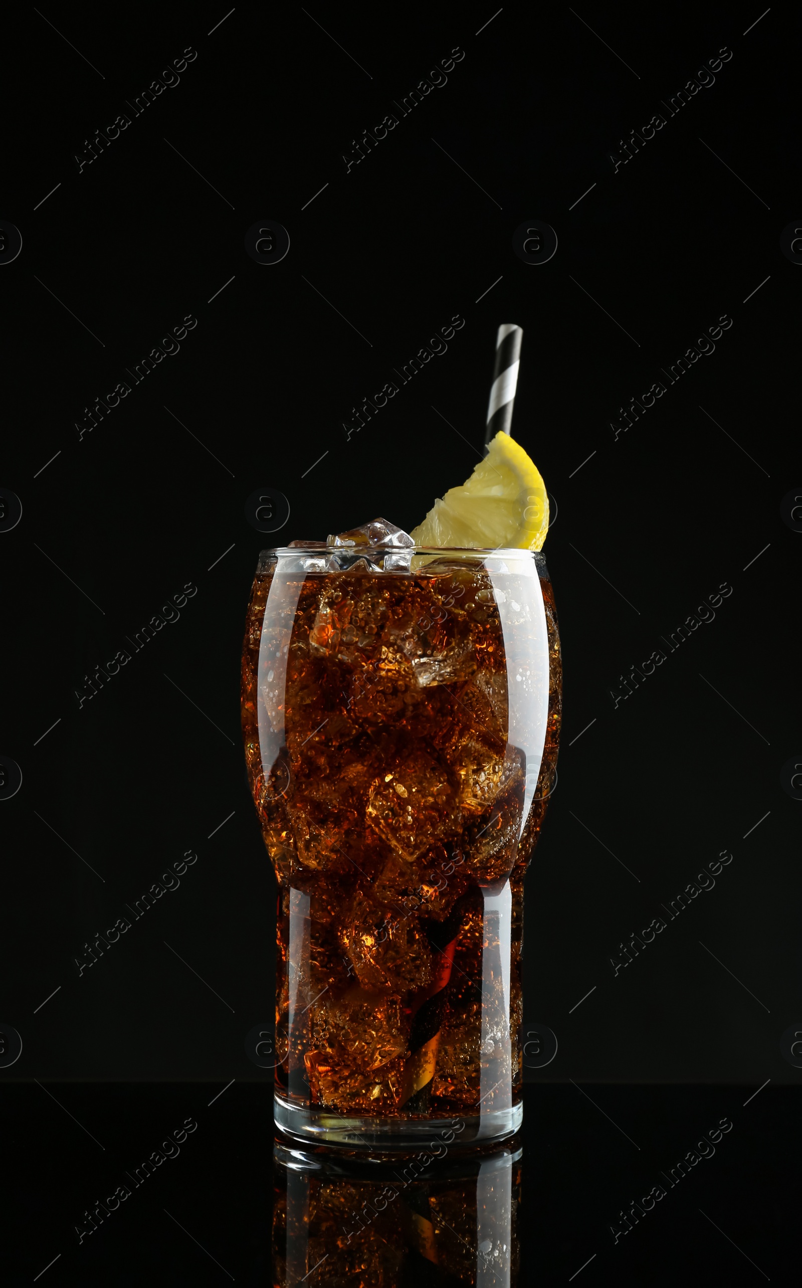 Photo of Glass of refreshing soda water with ice cubes and lemon slice on black background