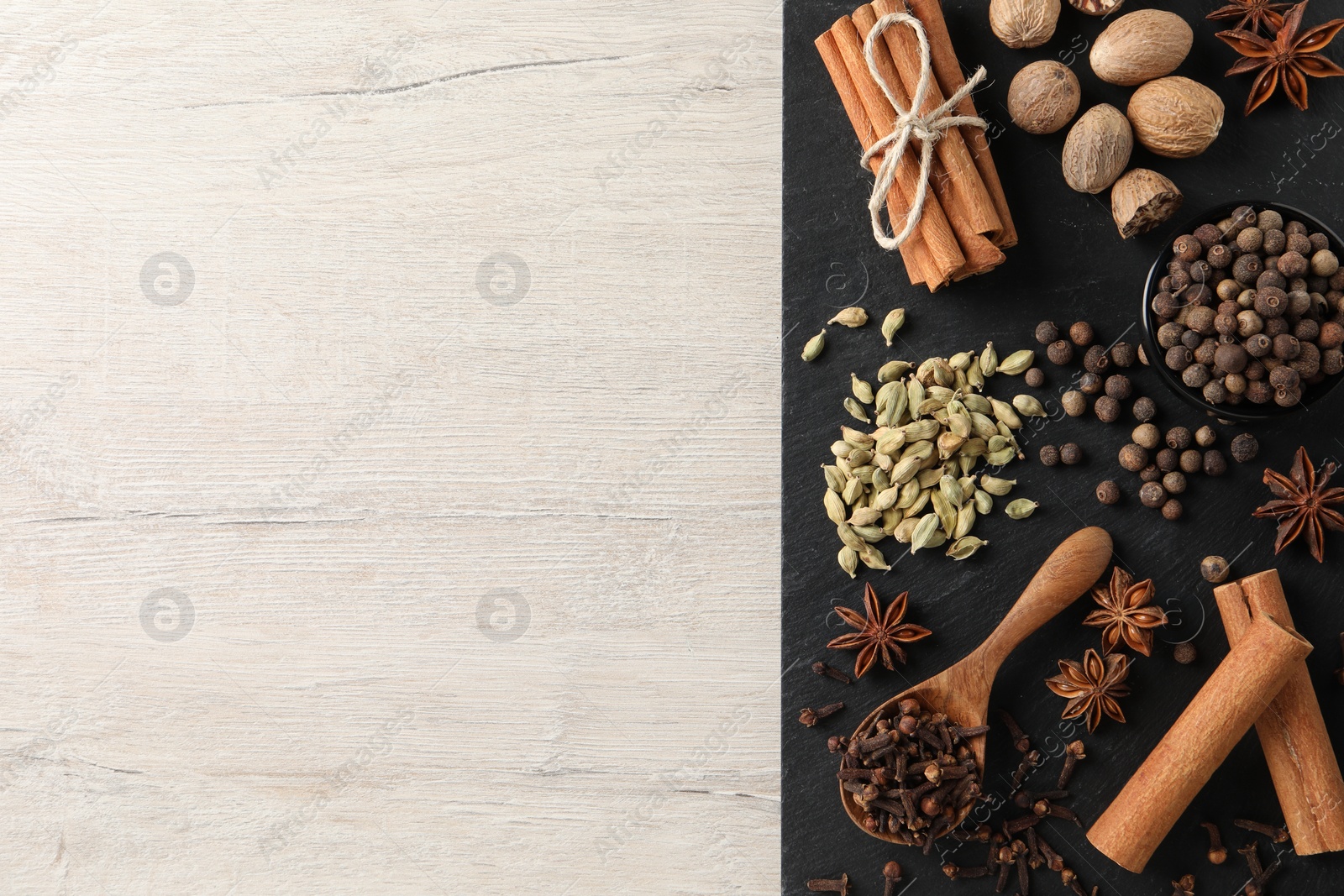 Photo of Different spices on wooden table, top view. Space for text