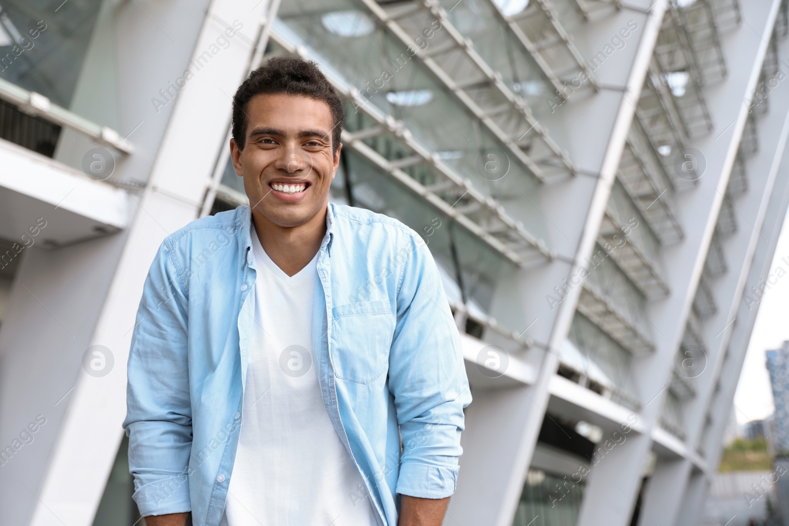 Photo of Portrait of handsome young African-American man on city street. Space for text