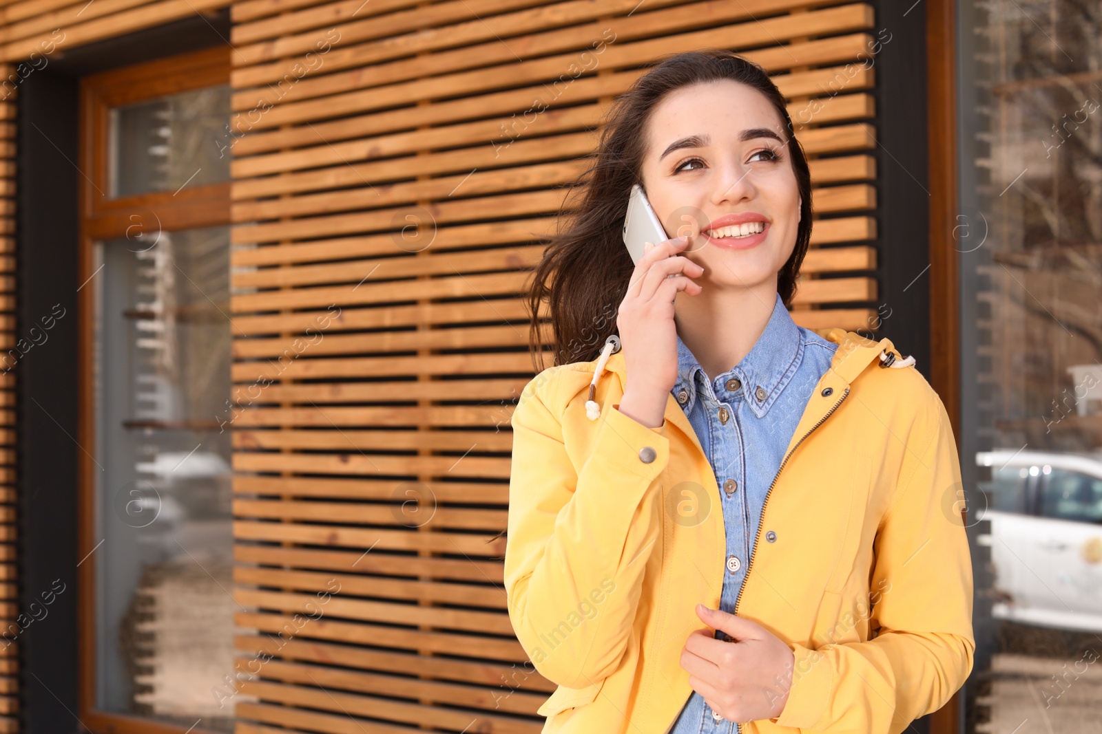 Photo of Beautiful young woman talking on phone outdoors